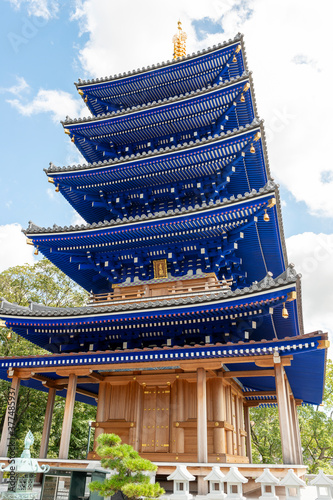 Blue colored five-storied pagoda of Nakayamadera temple in Takarazuka city, Hyogo, Japan.  Translation: two Chinese characters on the plate mean 