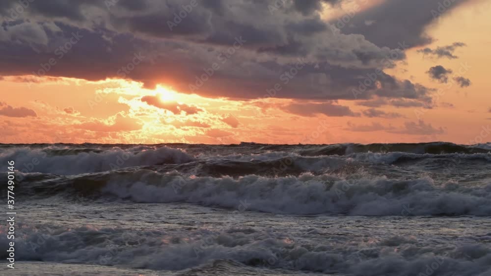 The surfer is trying to ride the wave. Stormy waves of the sea at sunset. The surfer is trying to ride the wave. Stormy waves of the sea at sunset.