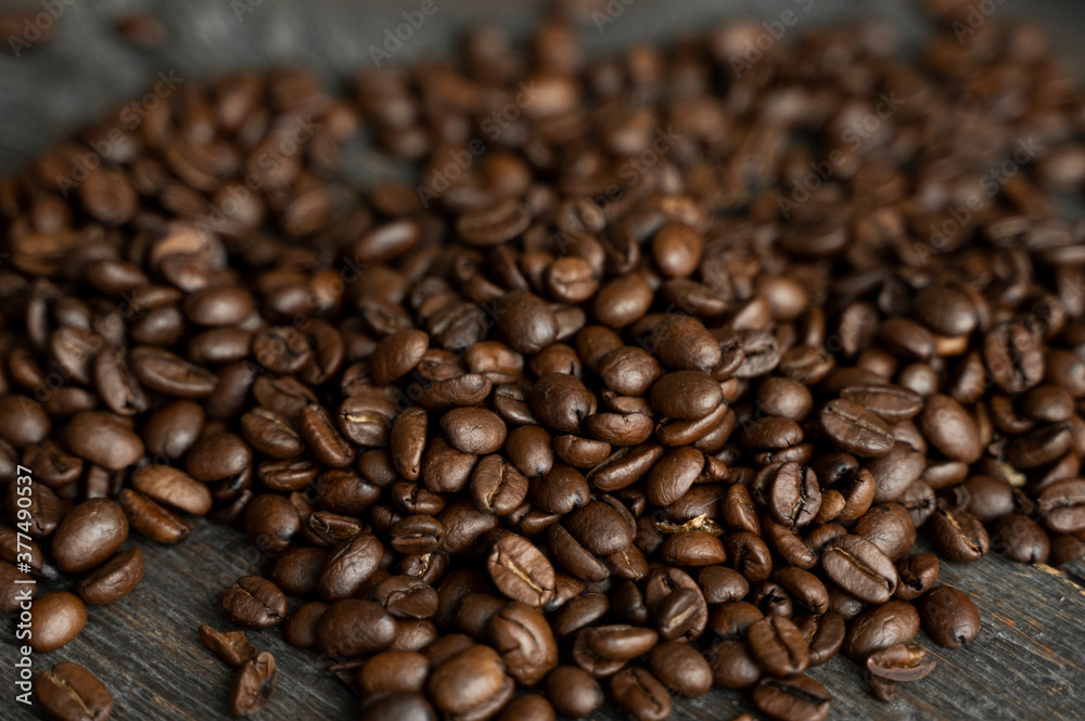 Roasted arabica coffee beans scattered on a wooden table. Fresh coffee beans.