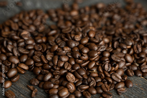 Roasted arabica coffee beans scattered on a wooden table. Fresh coffee beans. © Volodymyr