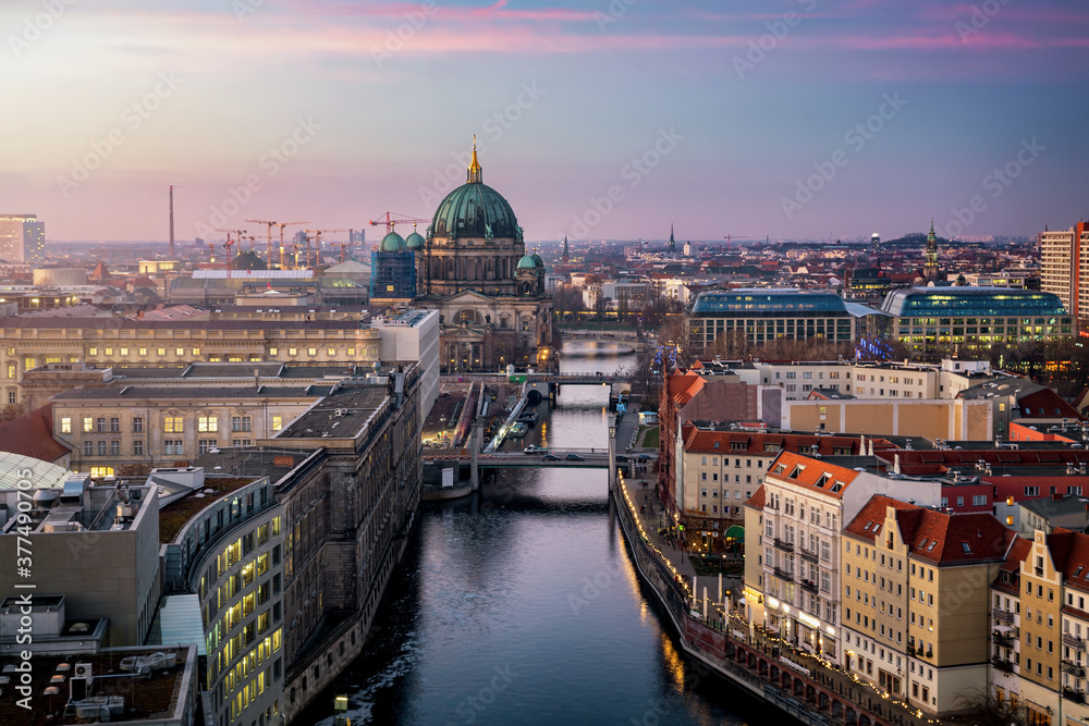 Blick entlang der Spree auf den Berliner Dom und die Skyline von Berlin, Deutschland, am Abend mit Stadt Lichtern und sanftem Himmel