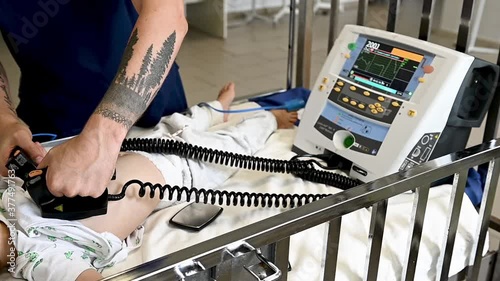 Doctor give resuscitation to a male patient in the emergency room. Cardiac massage. Defibrillation
