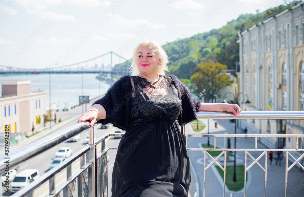 Plus size woman, American or European appearance walks in the city enjoying life. A young lady with excess weight, stylishly dressed in the center of the city. Natural beauty