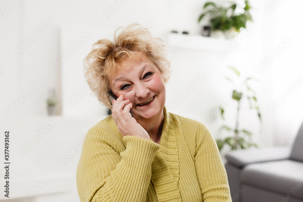 Happy senior woman talking on smartphone at home. Happy senior woman talking on smartphone at home.