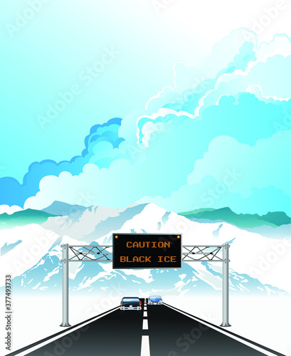 Caution black ice warning on overhead gantry sign on high altitude highway set against a blue cloudy sky