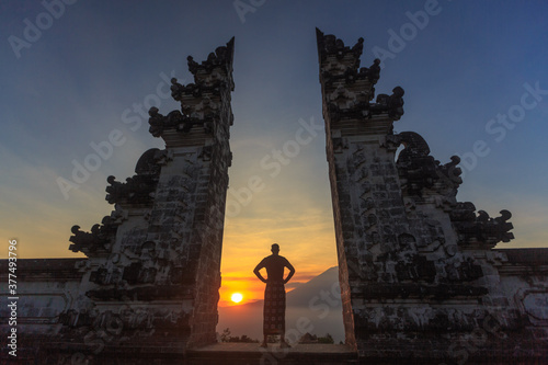 Amazing sunset on the ancient gates of Pura Luhur Lempuyang temple aka Gates of Heaven on volcano Agung background in Bali,Indonesia, man relaxting on gates. High quality photo photo