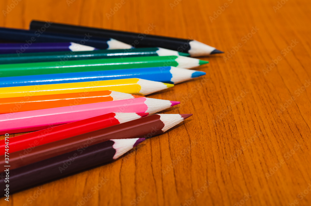 Fototapeta premium Color pencils on wooden background with copy space for text, banner design