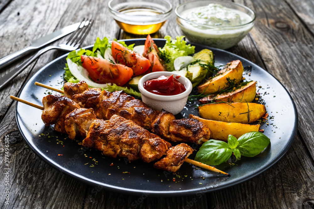 Fried souvlaki, potatoes with fresh vegetables 