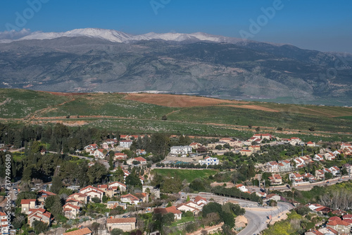 View of the town of Metula, situated on the Israeli-Lebanese border, at the foot of Mount Hermon (in the background), as seen from Dado lookout point, Upper Galilee, Israel.