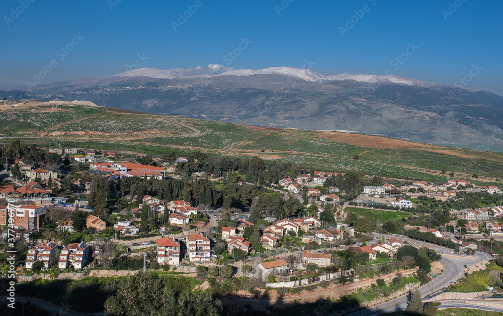 View of the town of Metula, situated on the Israeli-Lebanese border, at the foot of Mount Hermon (in the background), as seen from Dado lookout point, Upper Galilee, Israel.