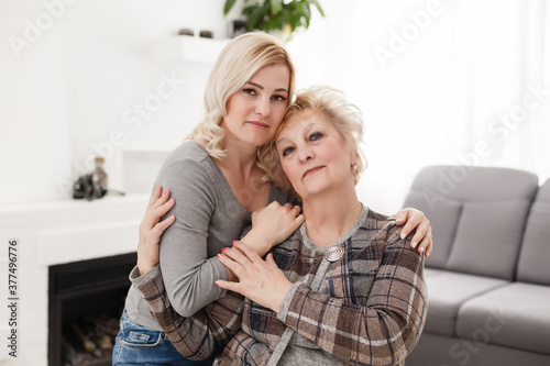 happy senior mother and adult daughter closeup portrait at home