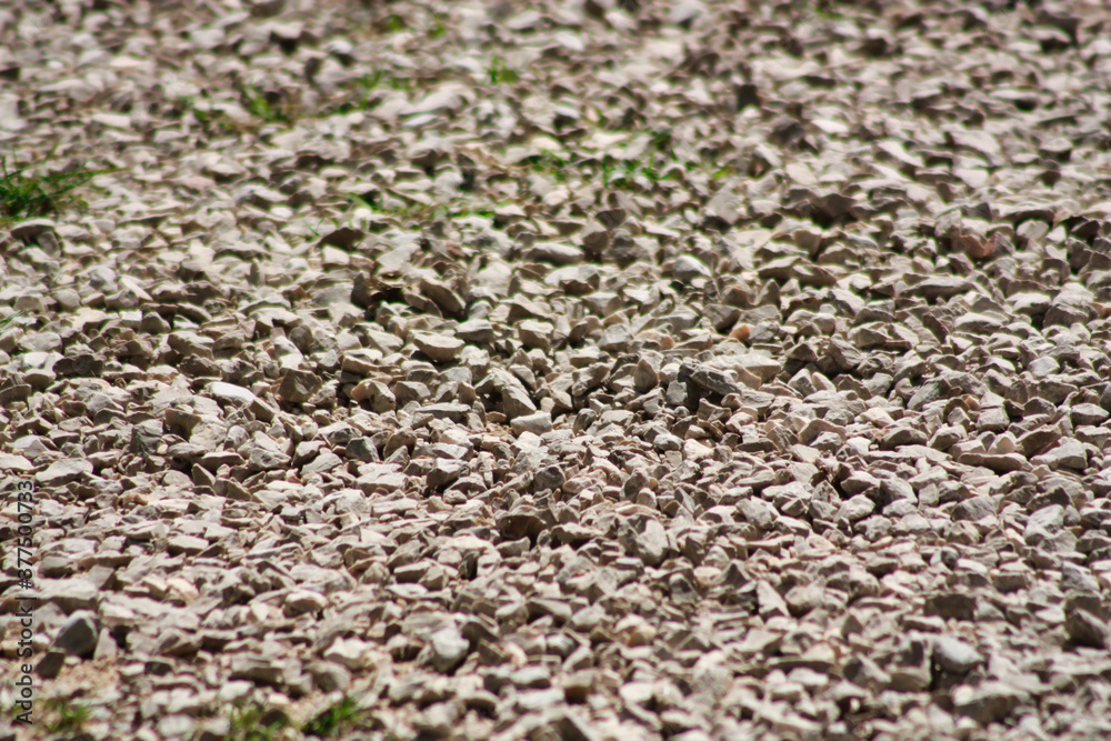 Gravel texture. Small stones, pebbles in many shades of grey colour. Crushed granite texture. Road made of stones. Gravel texture. Small stones, pebbles in many shades of grey colour. Crushed granite texture. Road made of stones.