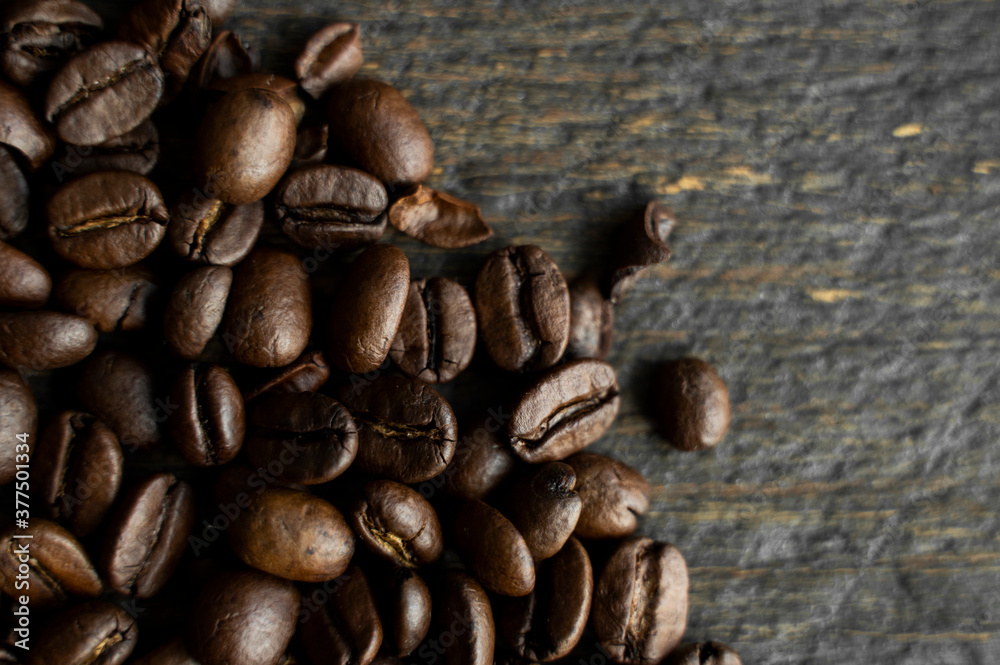 Roasted arabica coffee beans scattered on a wooden table. Fresh coffee beans. Roasted arabica coffee beans scattered on a wooden table. Fresh coffee beans.