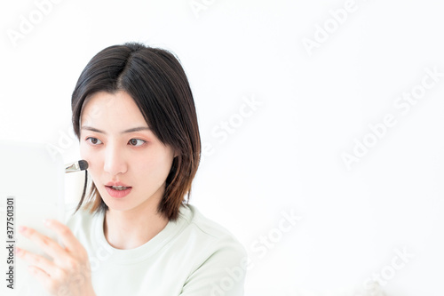 Asian woman doing makeup