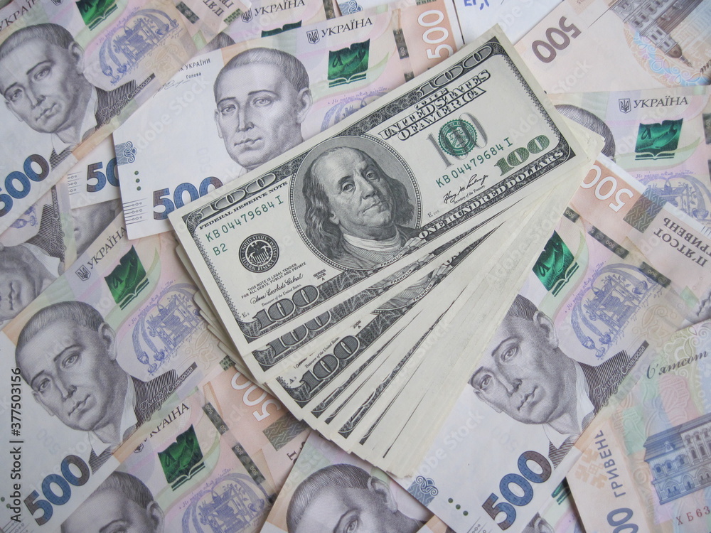 Financial background with a lot of paper banknotes of USA 100 dollars and Ukraine 500 hryvnia is great for editorial publication about money exchange. Financial background with a lot of paper banknotes of USA 100 dollars and Ukraine 500 hryvnia is great for editorial publication about money exchange.