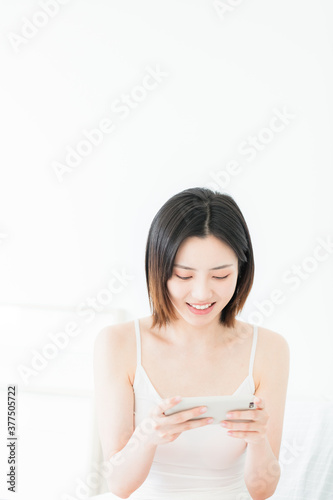 Asian woman using mobile phone indoors