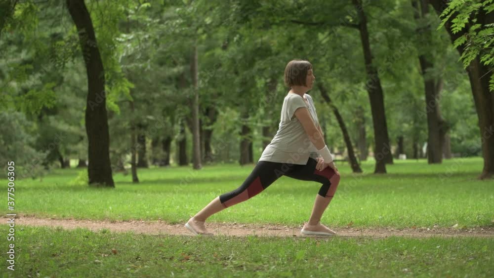 Female jogger stretching muscles and warming up for running exercise in park Female jogger stretching muscles and warming up for running exercise in park