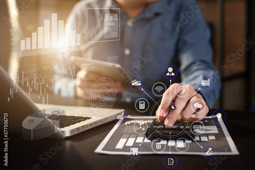 accountant working on laptop computer with business document, graph diagram and calculator on office table in office.