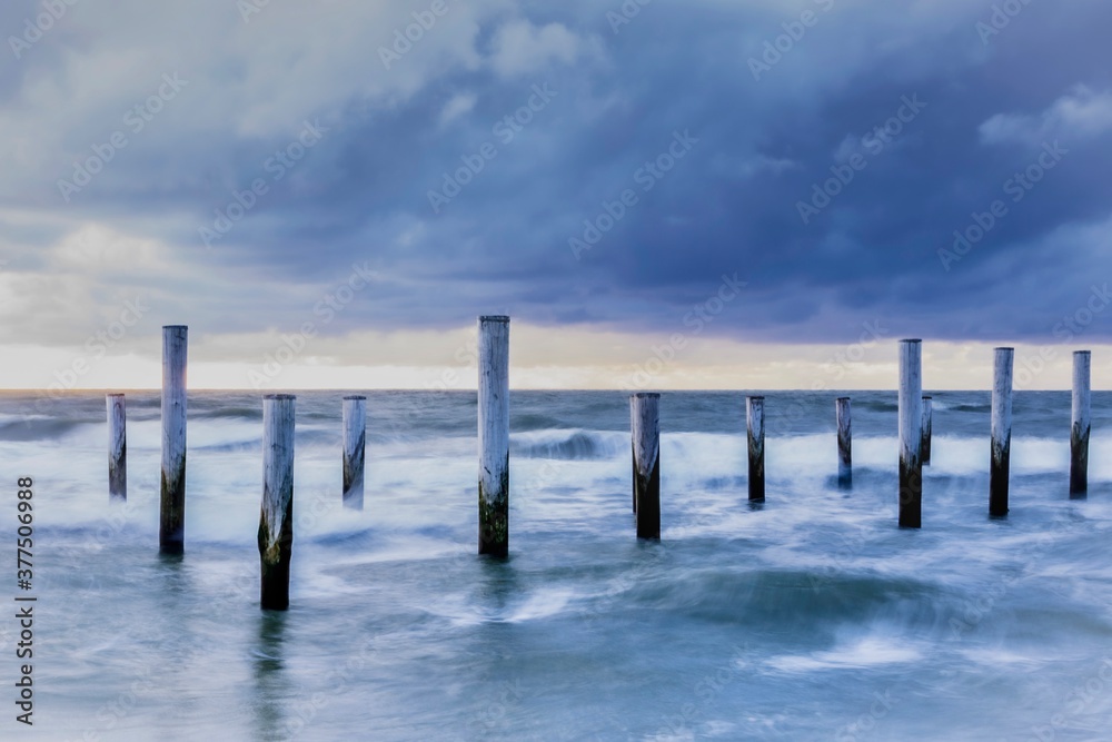 Group of poles down the sea shore
