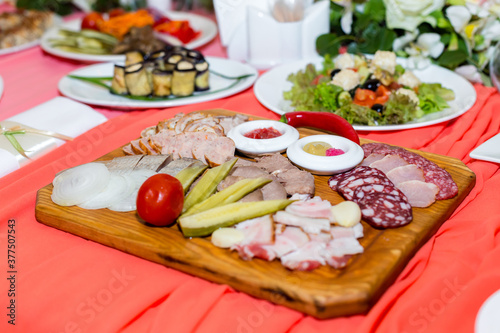 Sausages, cold cuts, dishes on a white banquet table