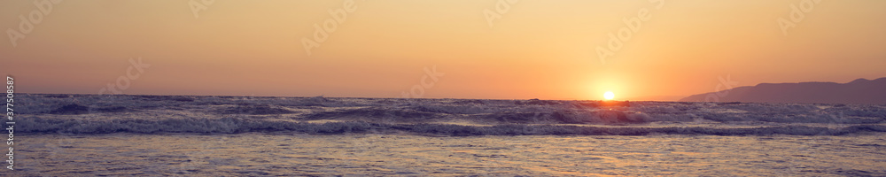 panoramic view of seascape with yellow sun ball on sea coast