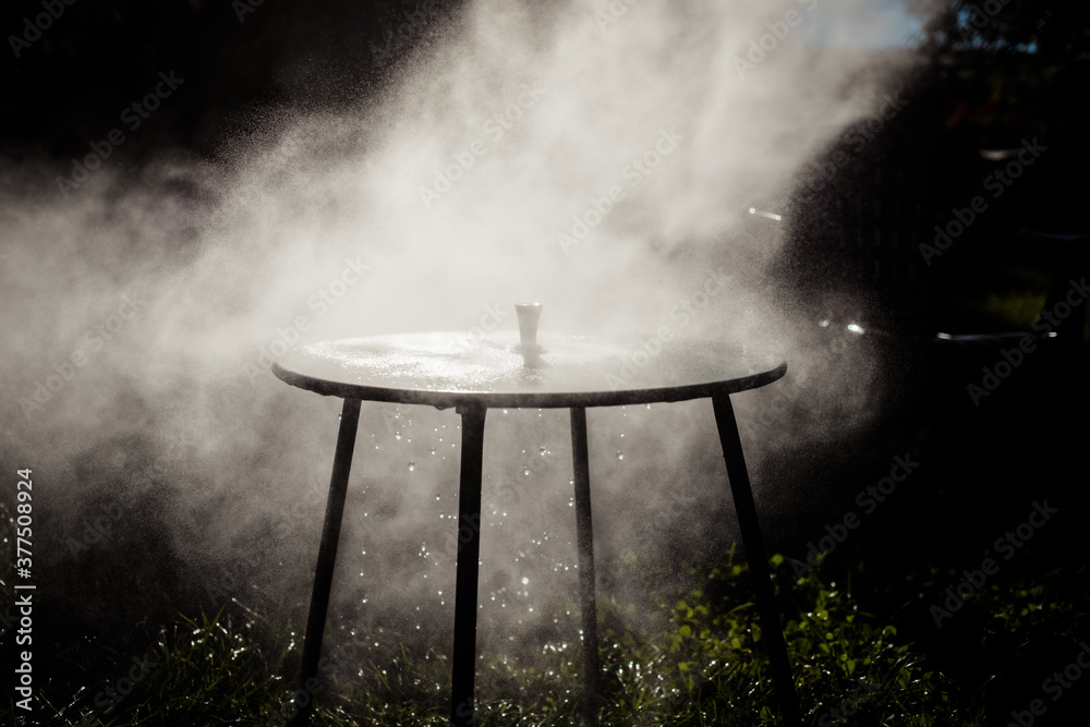 sanitizing a table outdoors contre jour