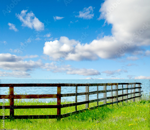 wooden fence on the river on a background of blue sky with clouds
