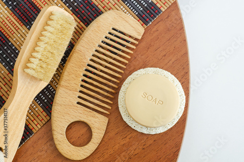 Bar of soap, wooden hair brush and body massage brush. Eco friendly toiletries. Natural beauty treatment, skin-care or zero waste concept. Top view, copy space.