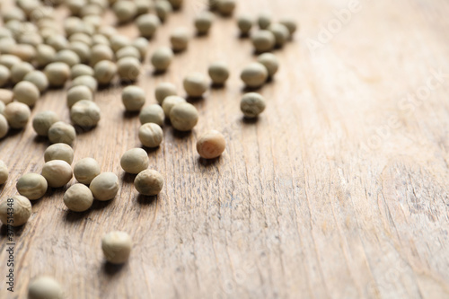 Raw dry peas on wooden background, closeup with space for text. Vegetable seeds