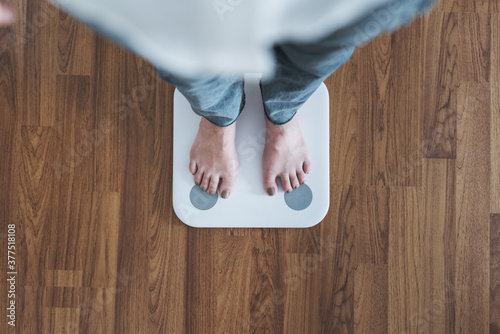 Top view, woman standing on body scale, checking body weight, dieting, lose and gain weight concept