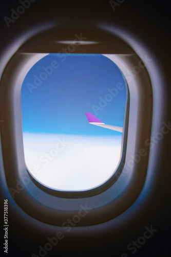 Beautiful scenic view sky through the aircraft window..Airplane interior with window view of blue sky and wing..Looking through window aircraft during flight in wing with a nice blue sky.