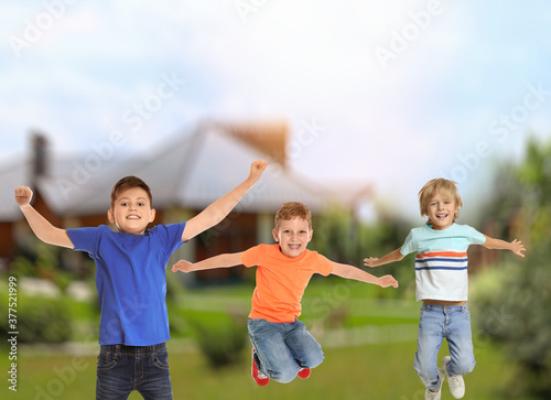 Happy boys jumping near house. School holidays