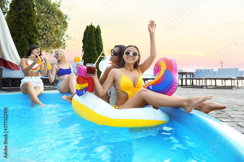 Group of happy people with refreshing drinks enjoying fun pool party © New Africa