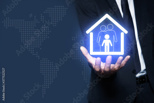 Property insurance concept. Man demonstrating house with family image  closeup