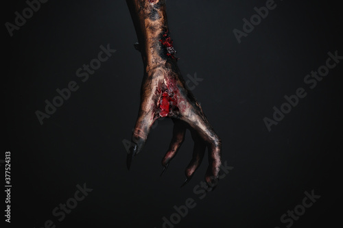 Scary monster on black background, closeup of hand. Halloween character