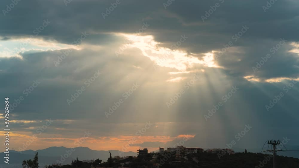 Time-lapse of clouds revealing sunbeams and sun Time-lapse of clouds revealing sunbeams and sun