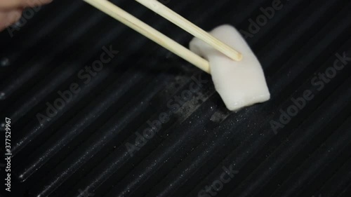 Person Grilled a Pork Lard on a Iron Skillet, Making Lard Oil before Eating Korean Barbecued.  Static shot and Closeup
