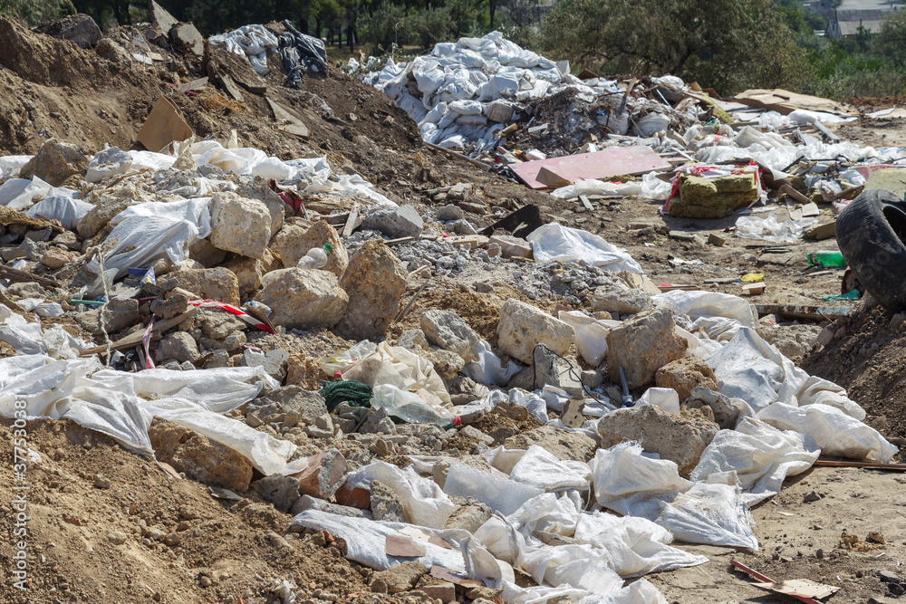 Pollution of the environment by people. Illegal garbage dump in the wasteland. A pile of household garbage in a dump in bags. A huge pile of waste extends to the garbage mountain Pollution of the environment by people. Illegal garbage dump in the wasteland. A pile of household garbage in a dump in bags. A huge pile of waste extends to the garbage mountain