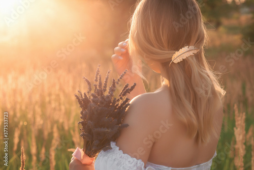 Girl with a bouquet of lavender and a gold hairpin in the setting sun