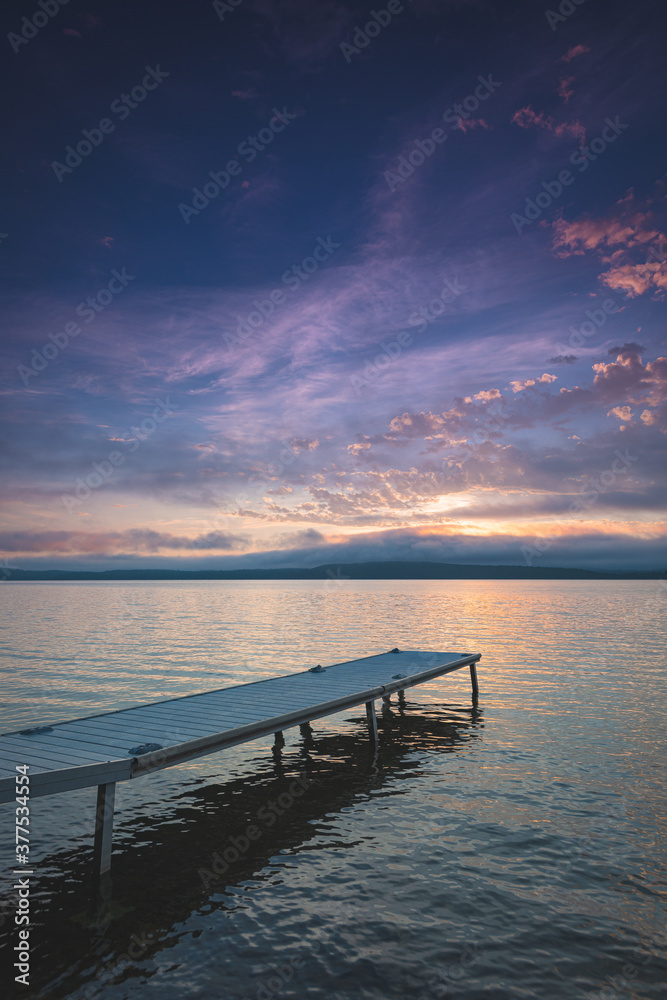 Bright color of the morning fill the sky over a dock on Lake Bernard in Ontario, Canada.