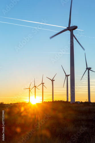 Wind Turbines at Dusk. Landscape sunset with windmills. Renewal source of electricity. Wind turbines field new technology for clean energy on mountain, sunset view with colorful twilight on sky