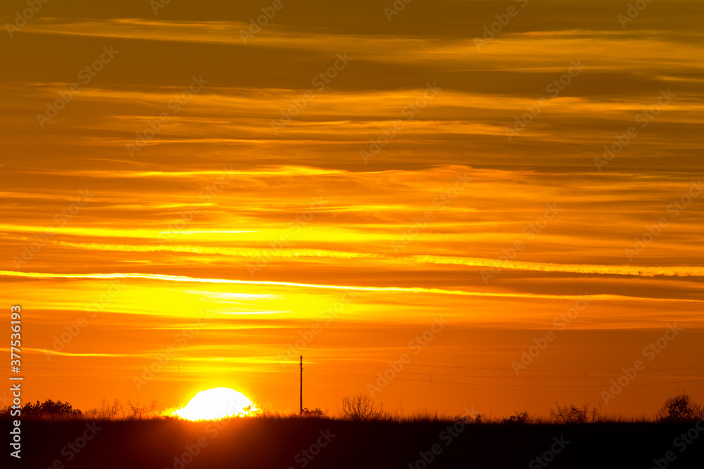 Beautiful sunset sky with colorful clouds in winter. Scenic sunset over sea surface. Natural scenery, beautiful landscape
