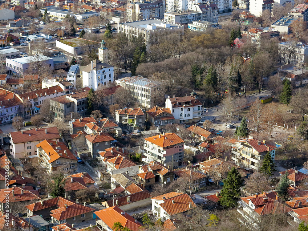 View of the roofs of red tiles from a bird's eye view. Picturesque bright roofs landscape of a small town in a mountain valley. Traditional tiled roof of a European city, Bulgaria.