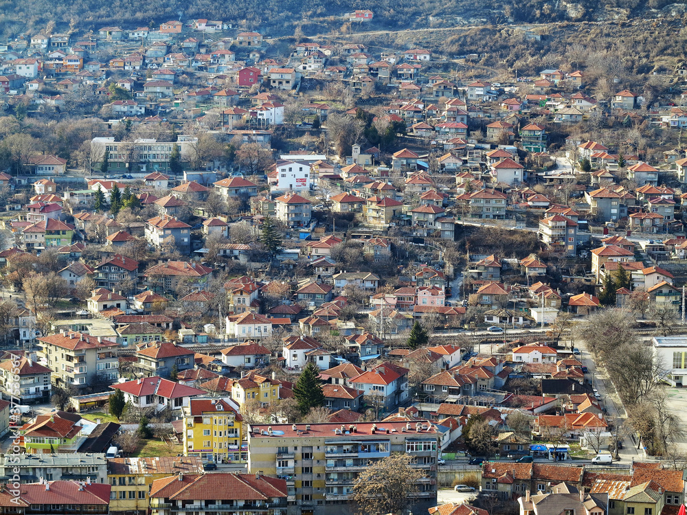 View of the roofs of red tiles from a bird's eye view. Picturesque bright roofs landscape of a small town in a mountain valley. Traditional tiled roof of a European city, Bulgaria.