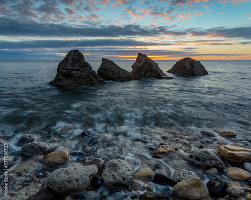 The Four Sisters, at sunrise. 4 pointed rocks on the beach at Grahams Sands, South Shields on the north east coast of England. UK. photo