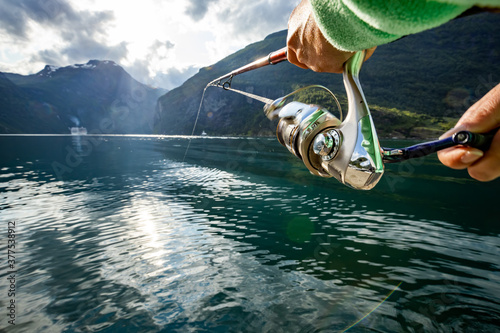 Murais de parede Woman fishing on Fishing rod spinning in Norway.