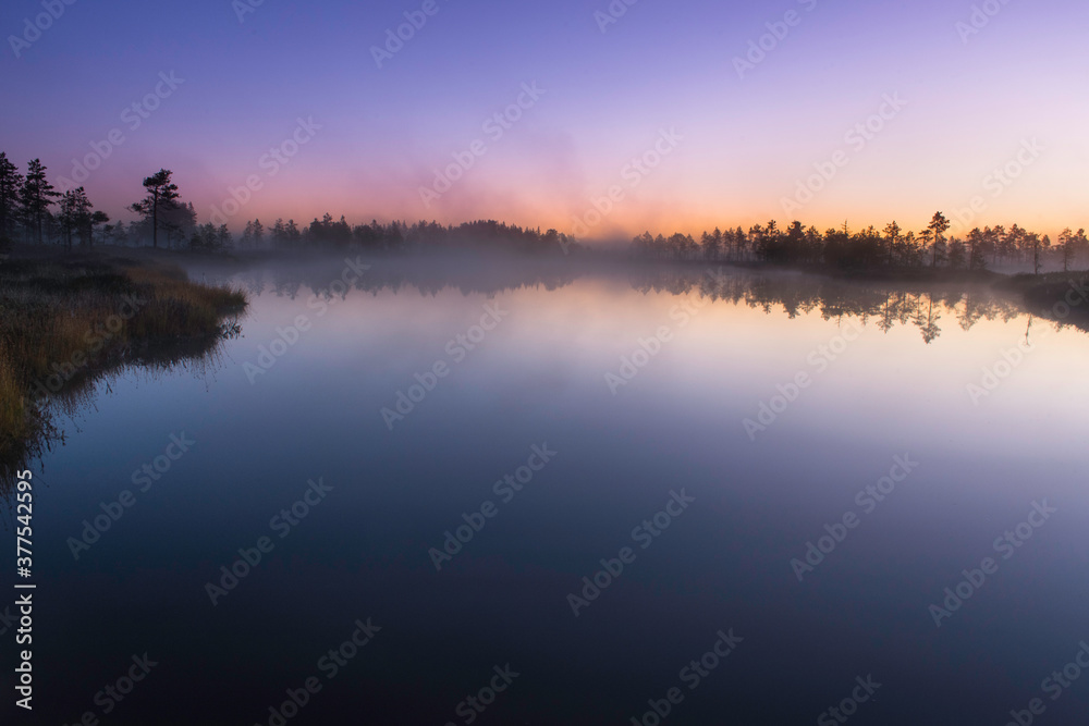 Twilight at sunrise over calm lake in autumn morning