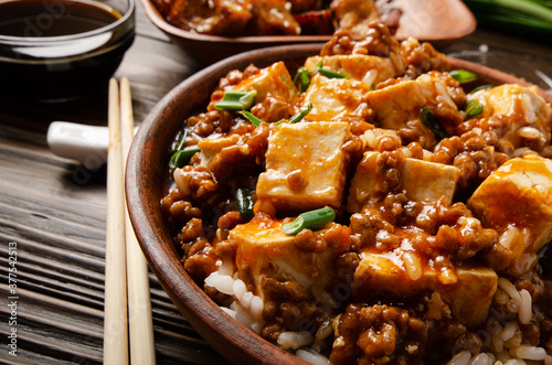 Authentic traditional Chinese food mapo tofu dish with pork chives steamed rice and soy sauce closeup