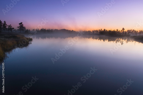 Twilight at sunrise over calm lake in autumn morning