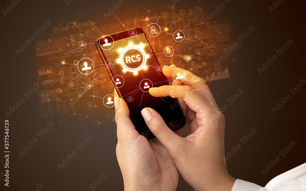 Female hand holding smartphone with RCS abbreviation, modern technology concept